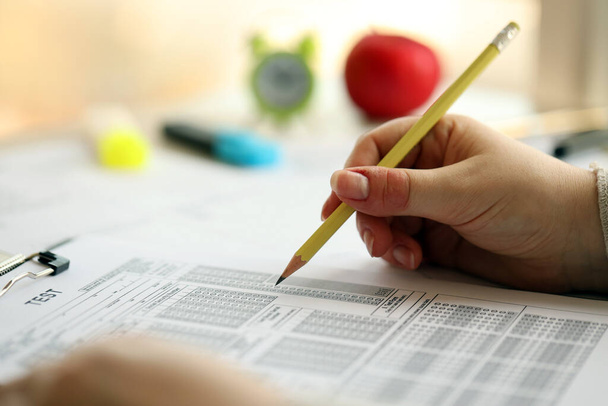 Тестирование женских рук и заполнение экзаменационного листа карандашом в школьном испытательном классе, концепция образования - Фото, изображение