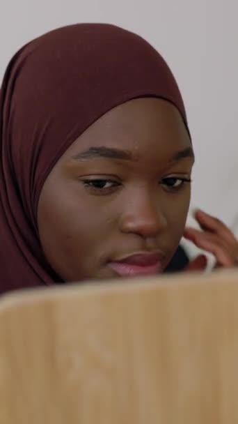 Mladý africký černošky dospívající dívka dívá do zrcadla zatímco uvedení muslimský šátek doma. Vertikální HD 9: 16 video.  - Záběry, video