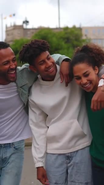 Szczęśliwej wielonarodowej grupy przyjaciół bawiących się na wakacjach. Wielokulturowi studenci śmieją się razem na ulicy. Społeczność młodzieżowa i koncepcja przyjaźni. Pionowe wideo z ekranem HD. - Materiał filmowy, wideo