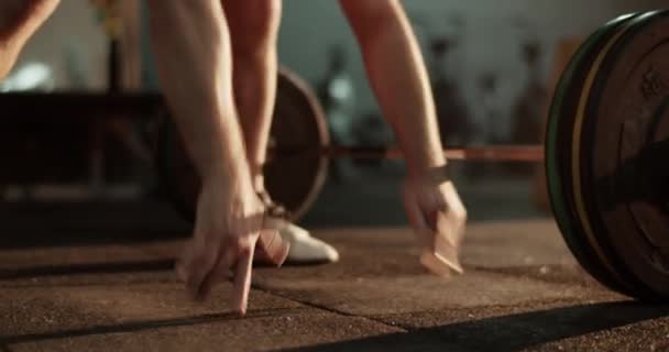 Volwassen mannelijke bodybuilder in sportkleding doen pushups oefening in de buurt van lange halter tijdens intensieve training in de sportschool - Video