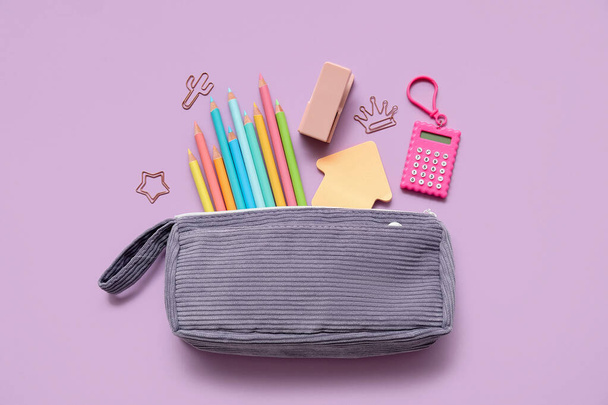 Caja de lápiz con diferentes artículos de papelería de la escuela sobre fondo púrpura - Foto, Imagen