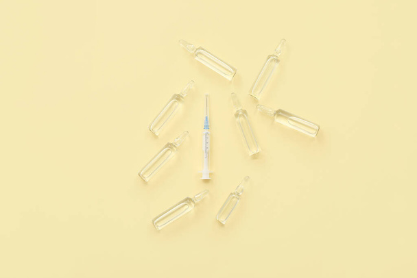 Empty syringe and ampoules with medicine on beige background - Photo, Image