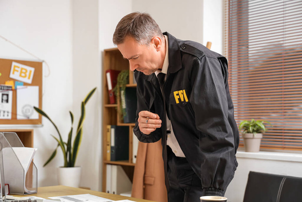 Agente maduro del FBI trabajando en la mesa en la oficina - Foto, imagen