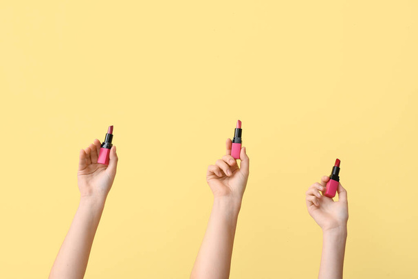 Naisten kädet huulipunat keltaisella pohjalla - Valokuva, kuva
