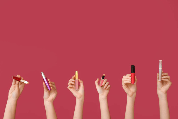 Nainen kädet huulipunat ja ripsiväri tummanpunainen tausta - Valokuva, kuva