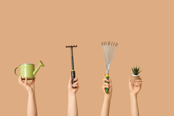 Kobiece ręce z narzędziami ogrodniczymi i roślin na tle koloru - Zdjęcie, obraz