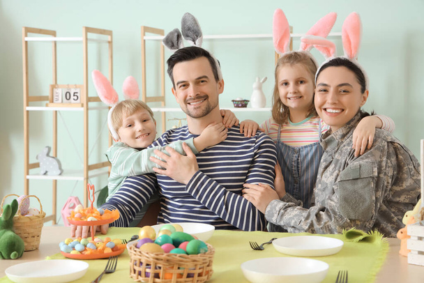 Female soldier with her family hugging at Easter dinner - Photo, Image