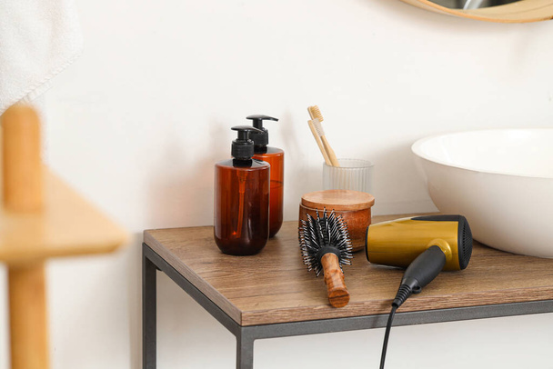 Escova redonda com secador de cabelo na mesa no banheiro, close-up - Foto, Imagem