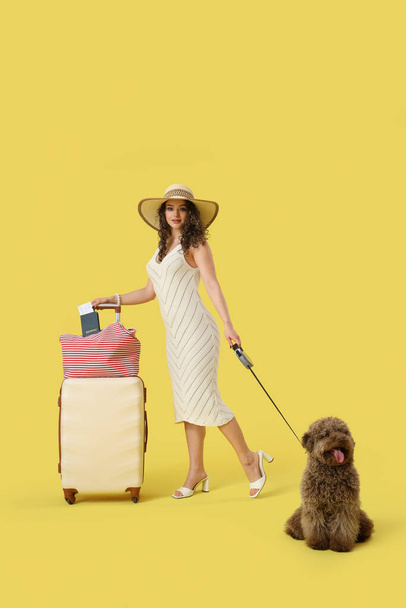 Voyageuse avec valise et caniche mignonne sur fond jaune - Photo, image