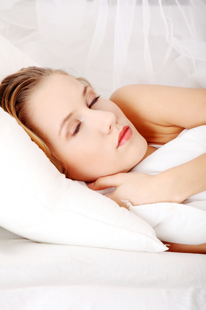 Молода жінка спить на ліжку
 - Фото, зображення