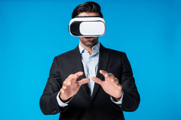 Розумний бізнесмен з костюмом, що тримає щось в той час як VR окуляри, щоб з'єднати метаверсію. Професійний менеджер проектів, який дивиться на голограму за допомогою гарнітури візуальної реальності. Технологічні інновації. Відраза. - Фото, зображення