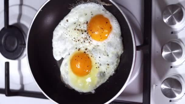 Deux œufs de poulet sont frits dans une poêle close-up. Concept petit déjeuner. - Séquence, vidéo