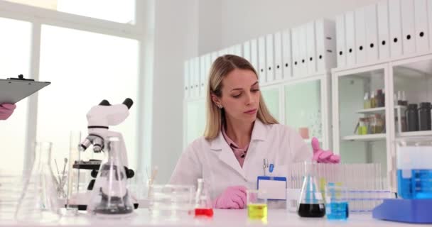 Deux scientifiques discutent des résultats de la recherche dans un laboratoire. Travail d'équipe dans un laboratoire pharmaceutique médical chimique - Séquence, vidéo