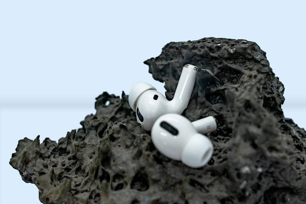 Pair of earpods placed in volcanic stone podium mockup 3D - Photo, Image