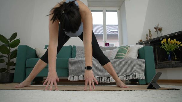 Fitness prénatal à la maison - Femme étirant le corps et les jambes au salon - Photo, image