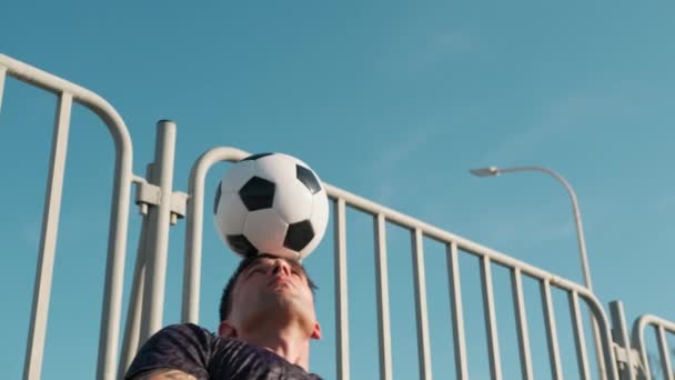 Αγόρι παίζει με μπάλα ποδοσφαίρου στο κεφάλι του. - Πλάνα, βίντεο
