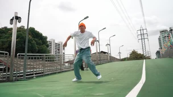 Professional hipster walking while doing freeze pose at bridge. Break dancer perform hip hop footstep surrounded by group of hipster cheering or encouraging friend. Outdoor sport 2024. Sprightly. - Footage, Video