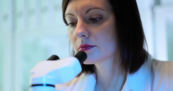 Kadın bir bilim adamı tarafından yapılan yeni bir patojenin mikroskobik analizi. Bilim ve eğitim kavramı - Video, Çekim