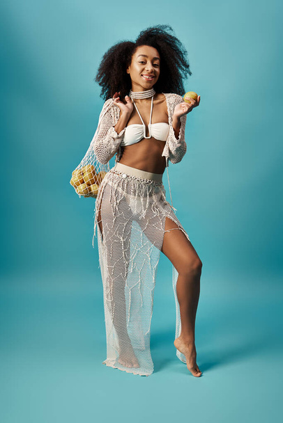 Tyylikäs nuori afroamerikkalainen nainen, jolla on donitsi trendikkäässä valkoisessa asussa. - Valokuva, kuva