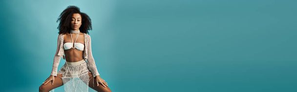Молодая афроамериканка, ставящая стильную позу на ярком синем фоне. - Фото, изображение