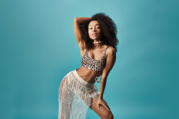 Молодая афроамериканка позирует в модном купальнике леопарда на ярком синем фоне. - Фото, изображение