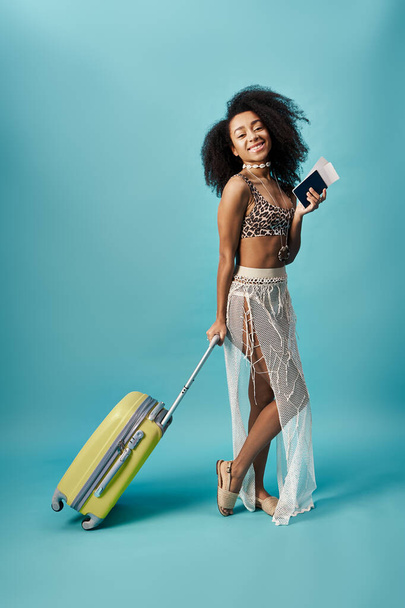 Tyylikäs nuori afroamerikkalainen nainen bikineissä pitäen matkalaukkua. - Valokuva, kuva