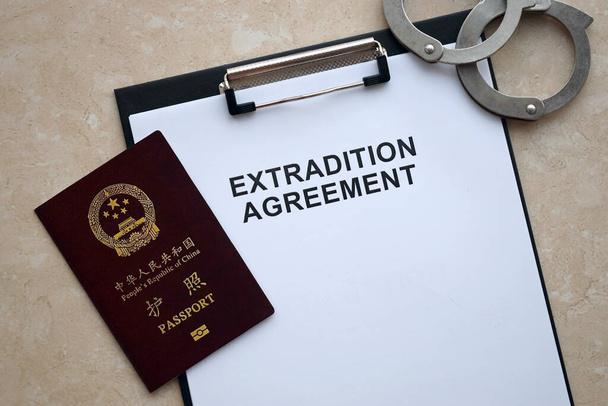 Pasaporte de la República de China y Acuerdo de Extradición con esposas en la mesa de cerca - Foto, Imagen
