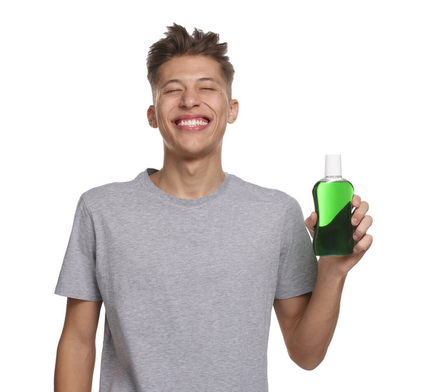 Young man with mouthwash on white background - Foto, Bild