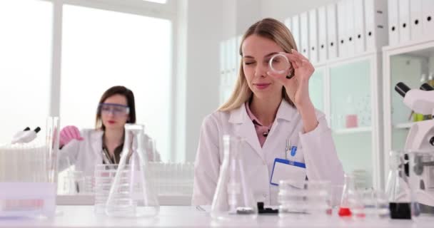 La ricerca scientifica nel mondo moderno, uno scienziato guarda attraverso una provetta. Moderno laboratorio chimico medico - Filmati, video