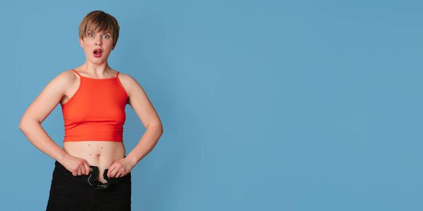 Porträt einer übergewichtigen Frau, auf die keine Kleidung passt, auf farbigem Hintergrund. Das Konzept eines gesunden Körpers, Körper positiv. Panorama-Banner. Kopieren des Raumes - Foto, Bild