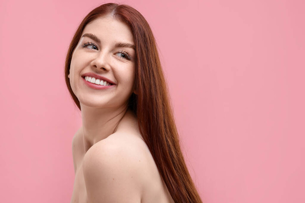 Portrait of smiling woman with freckles on pink background. Space for text - Photo, Image