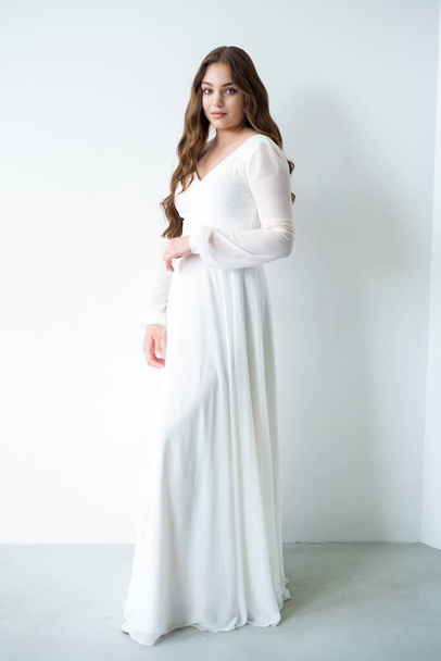 plan complet d'une belle jeune femme en robe blanche posant en studio - Photo, image