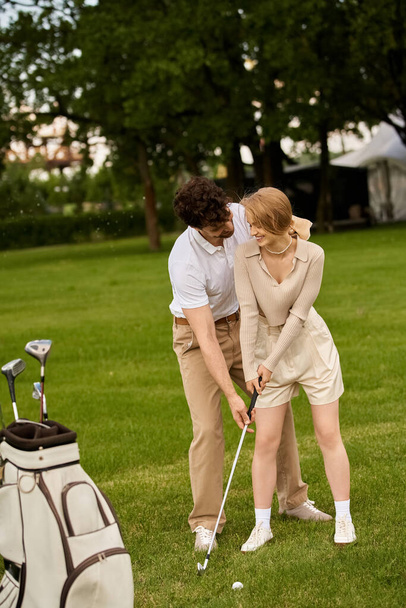 A young couple in elegant attire enjoying a game of golf on a sunny day at a prestigious golf club. - Photo, Image
