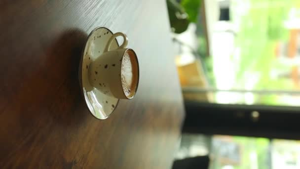 Cappuccino ou latte avec mousse mousseuse, tasse à café blanche sur la table dans un café. Café et bar, concept d'art barista. Des images FullHD de haute qualité - Séquence, vidéo