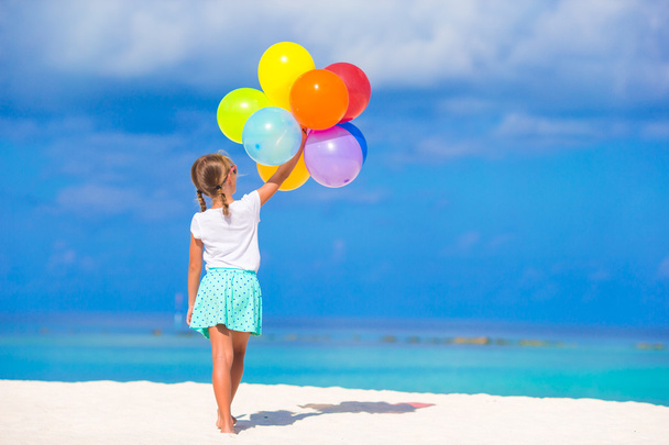Schattig meisje spelen met ballonnen op het strand - Foto, afbeelding