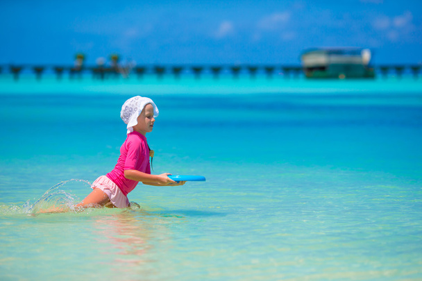 kleines Mädchen spielt mit fliegender Scheibe am Strand von Wnite - Foto, Bild