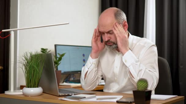 Stresszes felnőtt férfi szenved izmok feszültség, amelynek fájdalmas fejfájás miatt a számítógép túlmunka vagy ülő munka életmód. - Igen. Idős kor, középkorú, középkorú üzletember, aki otthon dolgozik - Felvétel, videó