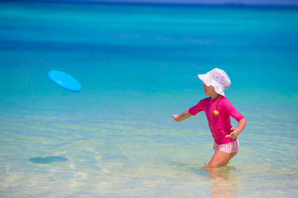 Niña jugando con disco volador en la playa wnite
 - Foto, imagen