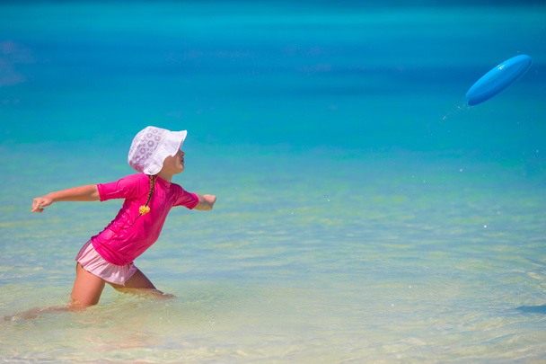 Маленькая девочка играет с летающим диском на wnite beach
 - Фото, изображение
