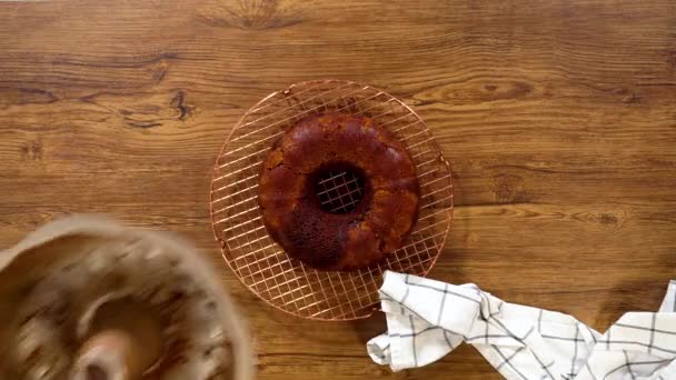 Ležel. Perníkový koláč jemně vyleze z formy na drátěný stojan, připravený na mrholení sladké karamelové polevy. - Záběry, video