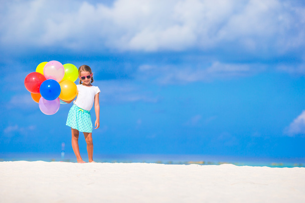 Αξιολάτρευτο κοριτσάκι παίζει με μπαλόνια στην παραλία - Φωτογραφία, εικόνα