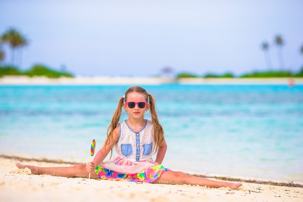 Little girl have fun with lollipop on the beach - Photo, Image