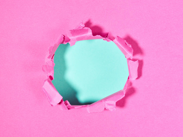 Rózsaszín papír tépett lyukkal a közepén - Fotó, kép