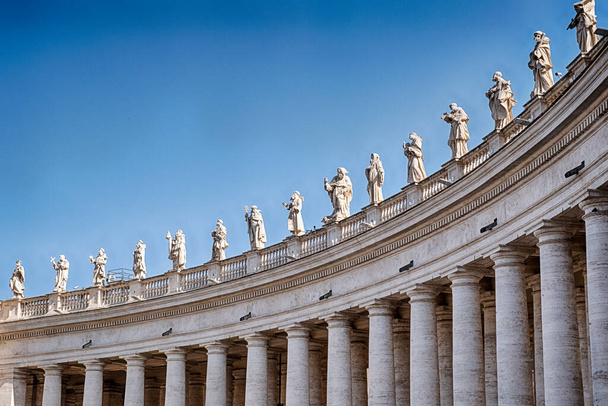 Vijftien heiligen lijn de top van de colonnade die de belangrijkste binnenplaats omsluit in de voorkant van de basiliek van St. Peter in Rome. - Foto, afbeelding