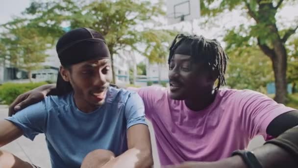 Retrato mediano de hombres afroamericanos que usan ropa deportiva mientras pasan tiempo al aire libre y miran la cámara - Metraje, vídeo