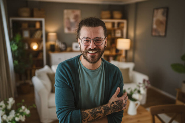 Retrato de hombres caucásicos adultos con gafas barba y tatuajes en casa feliz positivo - Foto, Imagen