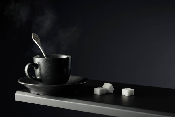 Xícara preta de café e açúcar em um fundo preto. Espaço de cópia. - Foto, Imagem