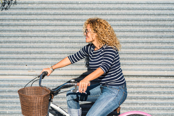 Bicicleta, mujer encantadora en la ciudad se siente serena y relajada mientras está al aire libre en verano con aspecto lindo. Transporte ecológico para reducir la huella de carbono de las mujeres en una bicicleta - Foto, imagen