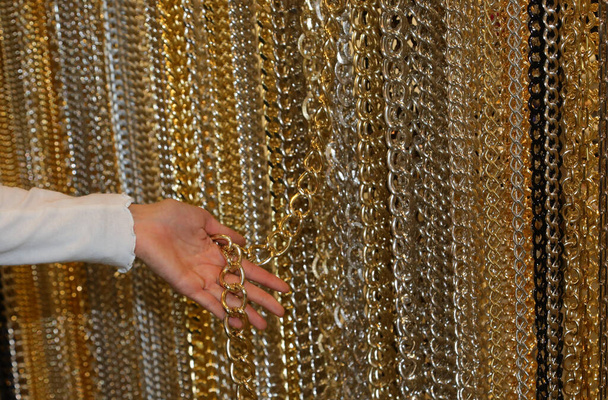 jeune femme tout en choisissant une chaîne en or pour créer un collier personnalisé dans le magasin - Photo, image