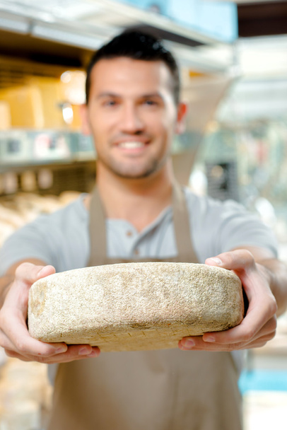 Man holding a wheel of cheese - Fotoğraf, Görsel